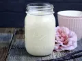 Selbstgemachter Kaffee-Sirup in einem Glas, mit Vanilleschoten und einer rosa Blume. Perfekt zum Kaffee creamer selber machen.