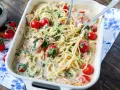 Cremige Lachs Spinat Pasta mit Kirschtomaten in einer Auflaufform, bereit zum Servieren.