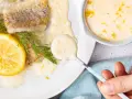 Gebratenes Fischfilet mit Zitronen-Butter-Sauce, garniert mit Dill und Zitronenscheibe.