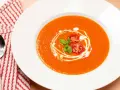 Ein Teller cremiger Tomatensuppe, garniert mit frischen Tomaten und Basilikum. Perfekt für ein einfaches Tomatensuppe Rezept mit frischen Tomaten.