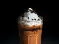 Eiskaffee selbst machen: Ein Glas mit cremigem Eiskaffee, Sahne und Schokostückchen. Perfekt für heiße Tage!
