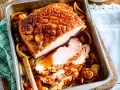 Saftiger Krustenbraten im Backofen, goldbraun und knusprig, mit Zwiebeln und Pilzen im Bratensaft. Ein Festmahl!