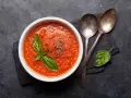 Schüssel mit frischer Tomatensuppe, garniert mit Basilikum. Perfekt, um Tomatensauce selber machen zu lernen.