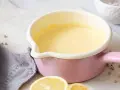 Frisch zubereitete Hollandaise in einem rosa Topf. So einfach ist es, Hollandaise selbst zu machen!