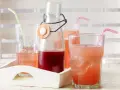 Erfrischender Rhabarbersirup im Glas mit Eis und Strohhalm. Ein tolles Rezept für den Sommer!