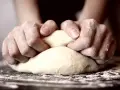 Hände kneten den pizzateig. Wie lange kneten? Bis er geschmeidig ist!