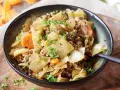 Herzhaftes Gericht aus spitzkohl mit hackfleisch und kartoffeln, garniert mit frischer Petersilie.