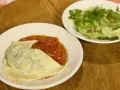 Ein Teller mit Maultaschen in Tomatensoße und ein kleiner Salat. Perfekt für ein schnelles Maultaschen Rezept.