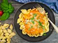 Schalen-Nudeln mit cremiger Tomaten-Sahne-Sauce, garniert mit Basilikum und Parmesan. Ein köstliches Gericht, das zum Genießen einlädt.