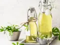 Zwei Flaschen mit selbstgemachtem Waldmeistersirup, dekoriert mit frischem Waldmeister.