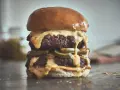 Ein saftiger Chili Cheese Burger mit zwei Patties, geschmolzener Käsesauce und Jalapeños.