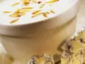 Cremige Gorgonzola-Sauce mit gerösteten Pinienkernen in einer Schüssel, daneben ein Stück Gorgonzola.
