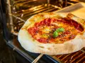 Frisch gebackene neapolitanische Pizza mit Tomaten, Mozzarella und Basilikum im Ofen. Ein perfektes neapolitanische Pizza Rezept.