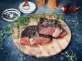 Perfekt gebratenes Rib Eye Steak, saftig und rosa, mit frischem Thymian und grobem Salz gewürzt. Ein Genuss für Fleischliebhaber.