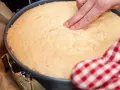 Ein Finger prüft die Elastizität eines frisch gebackenen Wiener Bodens. Das perfekte Wiener Boden Rezept gelingt so!