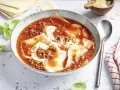 Herzhafte Lasagne Suppe in einer Schüssel, mit Hackfleischsauce, Nudelplatten und einem Klecks Sahne. Frisch garniert mit Basilikum.