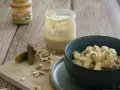 Selbstgemachte vegane Mayonnaise aus Cashews, serviert mit Kartoffelsalat und Gewürzgurken.