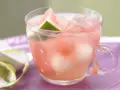 Erfrischende melonenbowle ohne alkohol in einem Glas mit Wassermelonenstücken und Eiswürfeln.