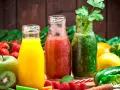 Drei Flaschen mit frisch gepresstem Saft: gelb, rot und grün. Perfekt, um Saft selber machen zu lernen und gesunde Getränke zu genießen.
