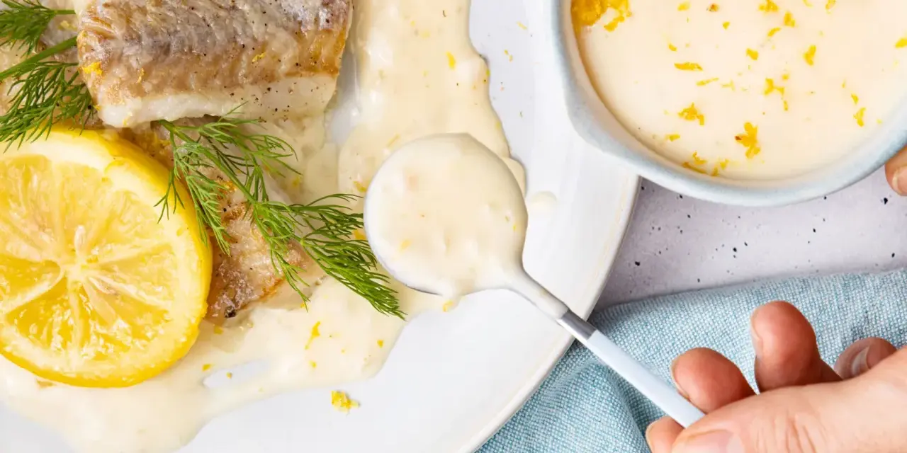 Gebratenes Fischfilet mit Zitronen-Butter-Sauce, garniert mit Dill und Zitronenscheibe.