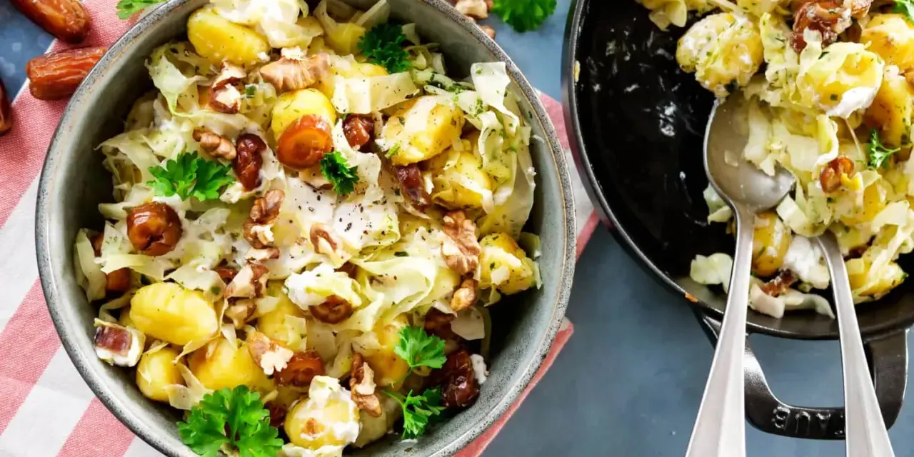 Leckeres rezept mit spitzkohl, Kartoffeln, Datteln und Walnüssen in cremiger Soße, garniert mit Petersilie.