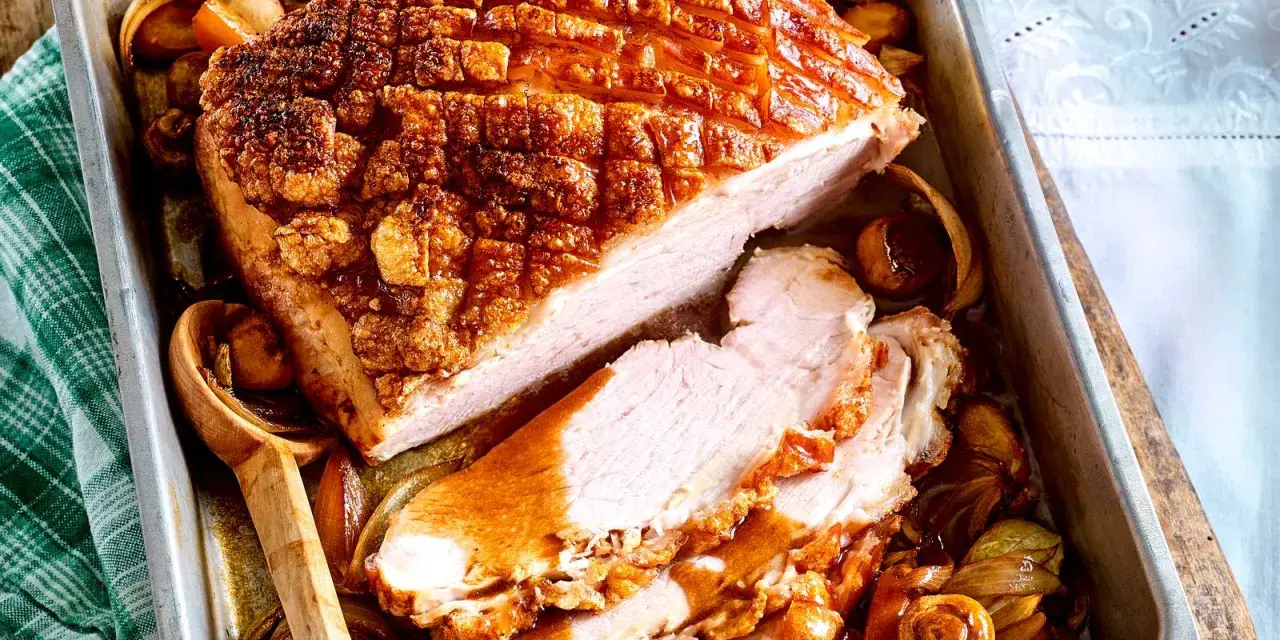 Saftiger Krustenbraten im Backofen, goldbraun und knusprig, mit Zwiebeln und Pilzen im Bratensaft. Ein Festmahl!