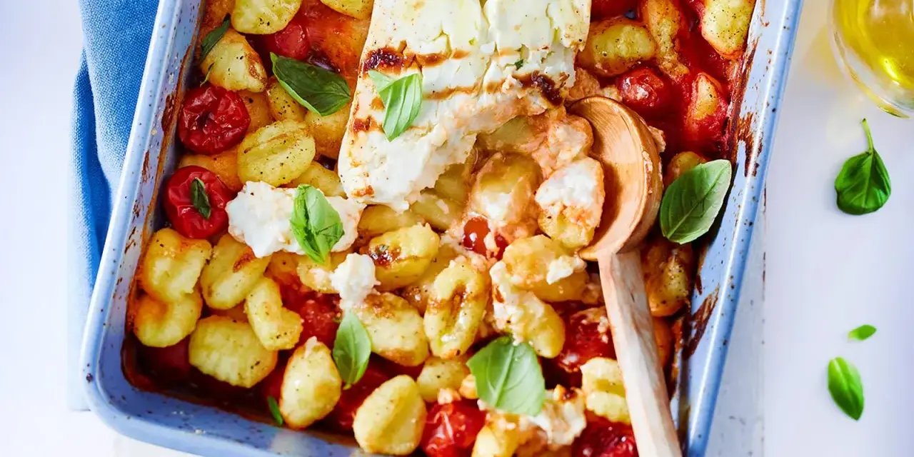 Gnocchi-Pfanne mit Feta, Kirschtomaten und Basilikum in einer blauen Auflaufform, bereit zum Servieren.