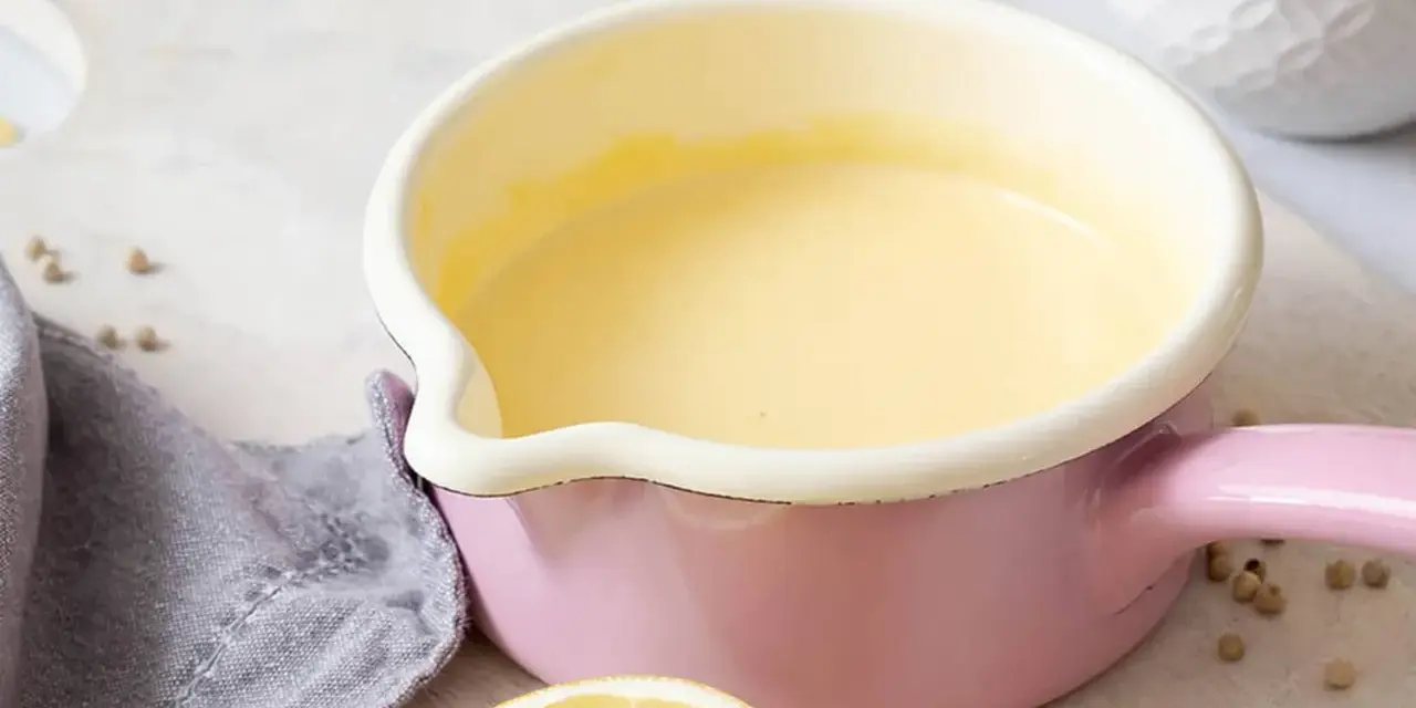 Frisch zubereitete Hollandaise in einem rosa Topf. So einfach ist es, Hollandaise selbst zu machen!