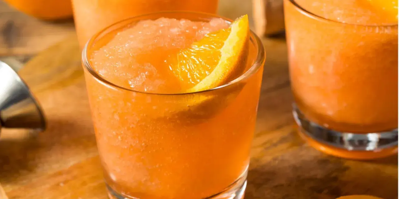 Erfrischender Aperol mit Fanta, als Slush serviert und mit einer Orangenspalte garniert. Perfekt für heiße Tage!