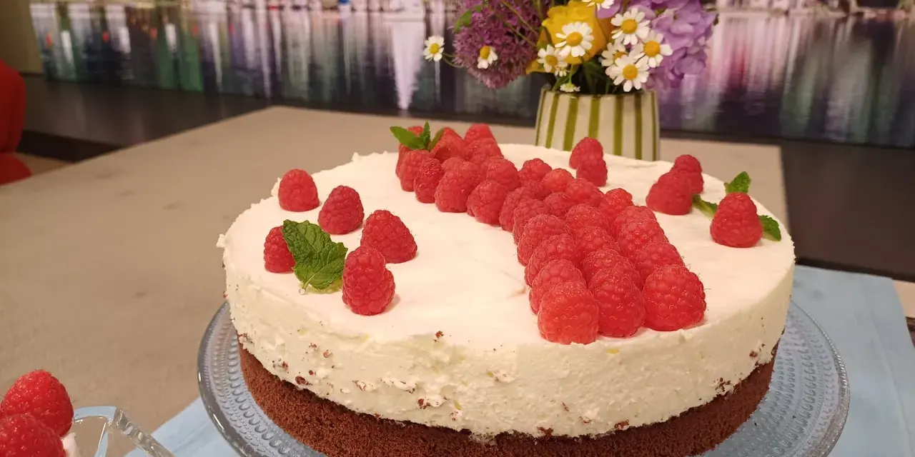 Himbeer Mascarpone Torte mit frischen Himbeeren und Minze verziert, ein Genuss für Augen und Gaumen.