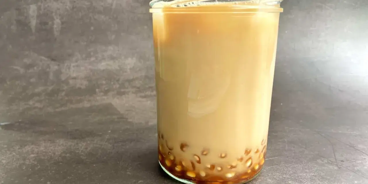 Ein Glas cremiger Milch-Tee mit Tapiokaperlen am Boden. Das ist, was Bubble Tea ausmacht!