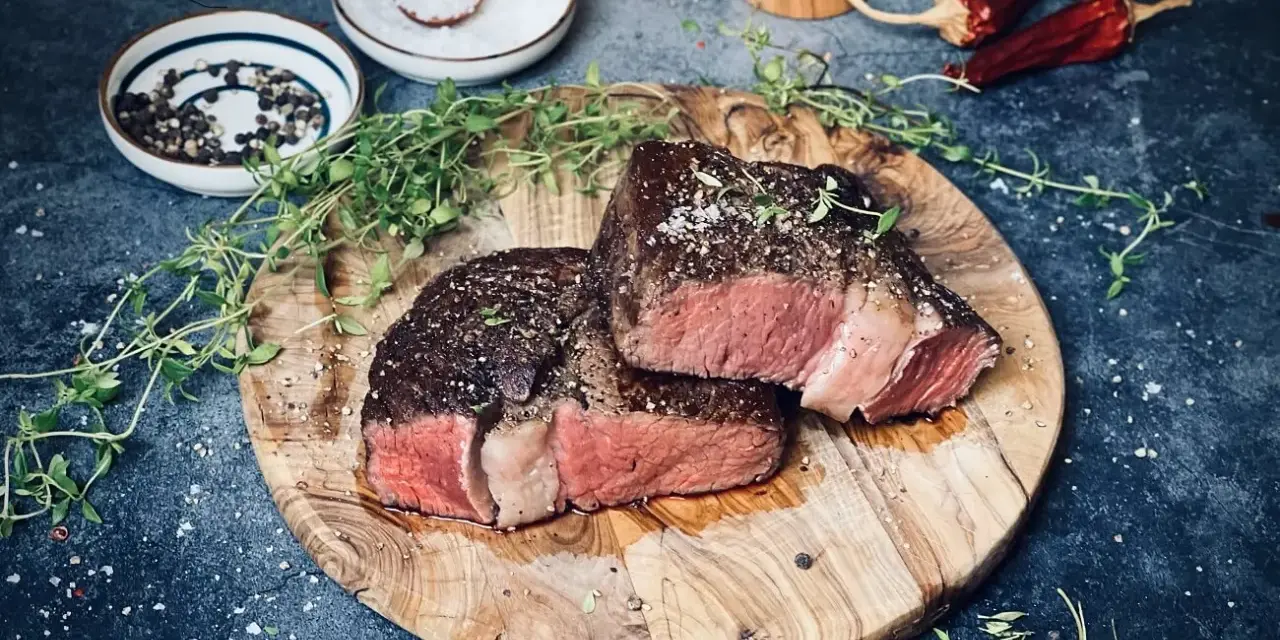 Perfekt gebratenes Rib Eye Steak, saftig und rosa, mit frischem Thymian und grobem Salz gewürzt. Ein Genuss für Fleischliebhaber.