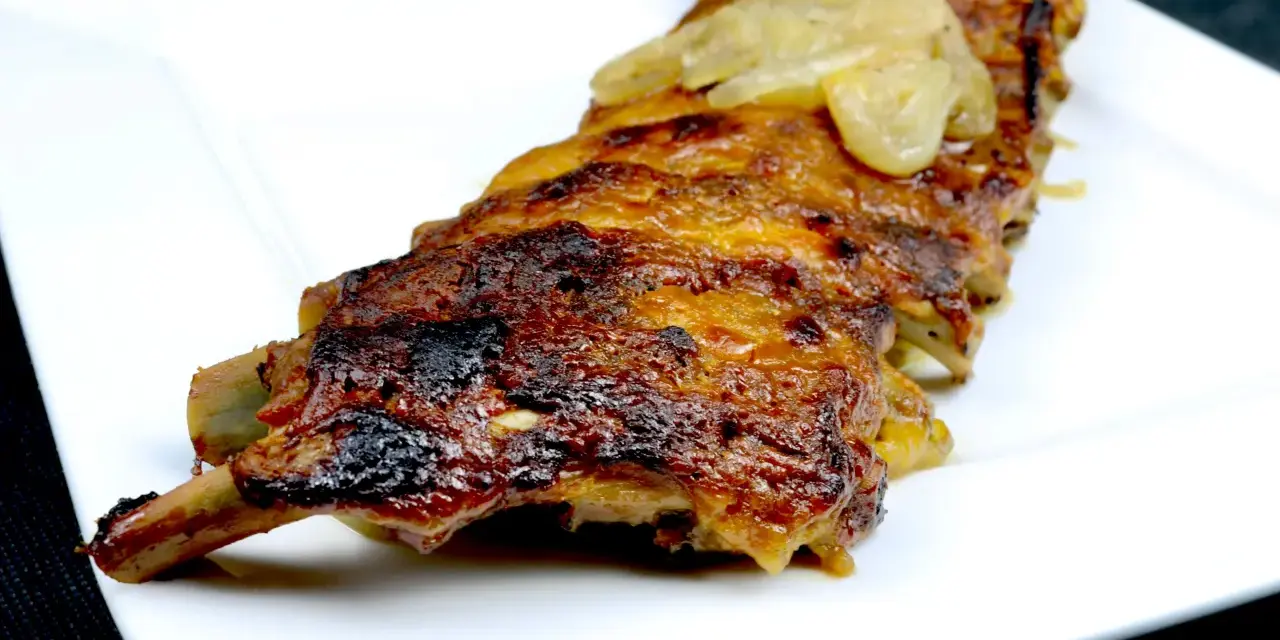 Saftige Rippchen, glasiert mit einer Honig-Senf-Marinade, serviert auf einem weißen Teller.
