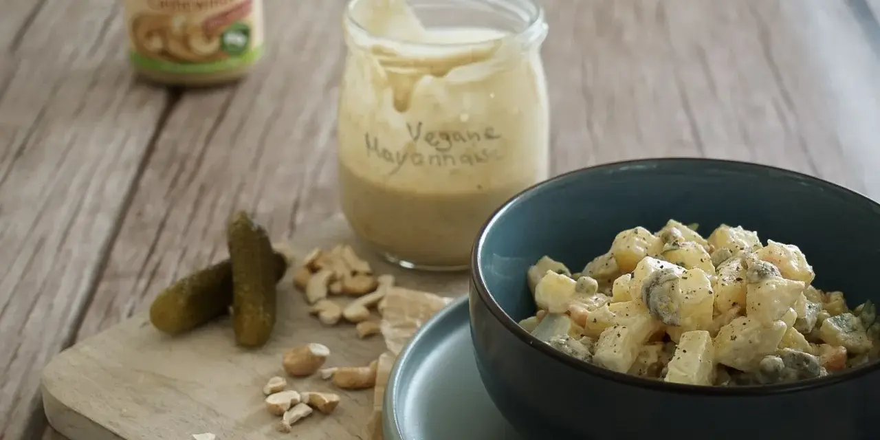 Selbstgemachte vegane Mayonnaise aus Cashews, serviert mit Kartoffelsalat und Gewürzgurken.