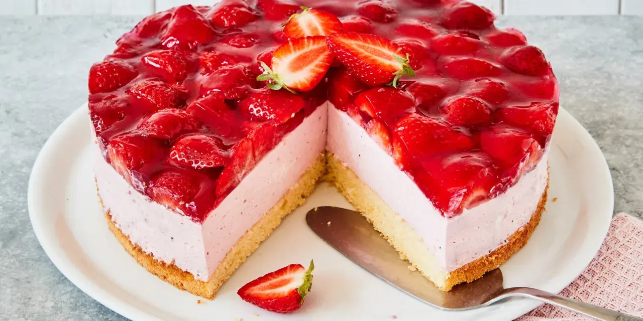 Eine köstliche Erdbeer Mascarpone Torte, üppig belegt mit frischen Erdbeeren und glänzendem Tortenguss. Ein Stück fehlt bereits.