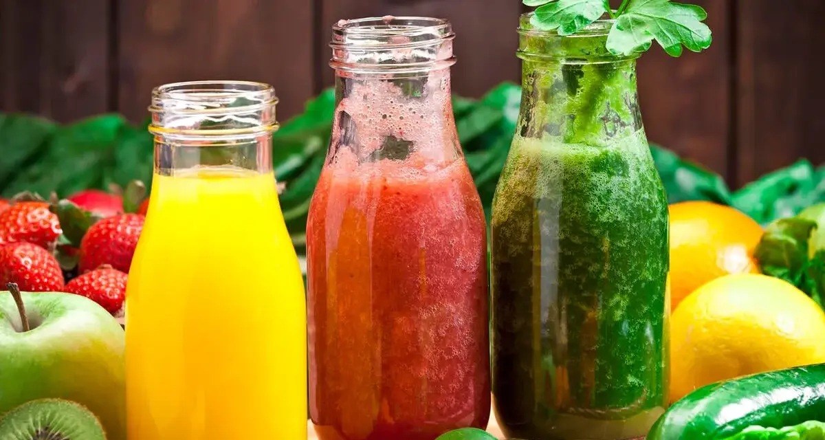 Drei Flaschen mit frisch gepresstem Saft: gelb, rot und grün. Perfekt, um Saft selber machen zu lernen und gesunde Getränke zu genießen.