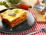 Ein Stück Lasagne mit Käse überbacken, garniert mit Basilikum. Perfekt für ein köstliches Lasagne Rezept.