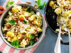 Leckeres rezept mit spitzkohl, Kartoffeln, Datteln und Walnüssen in cremiger Soße, garniert mit Petersilie.