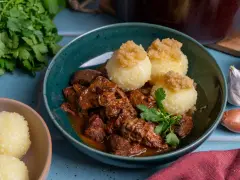 Herzhaftes Rindergulasch nach Omas Rezept, serviert mit Klößen und frischer Petersilie. Ein Klassiker, der immer schmeckt.