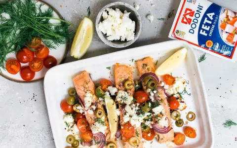 Ofenlachs mit Feta und Tomaten, garniert mit Dill und Zitrone. Ein köstliches Gericht, das nach Sommer schmeckt.