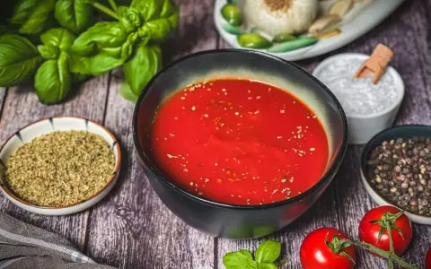 Frische Zutaten für Pizzasauce selber machen: Tomaten, Basilikum, Knoblauch, Oregano, Salz und Pfeffer.