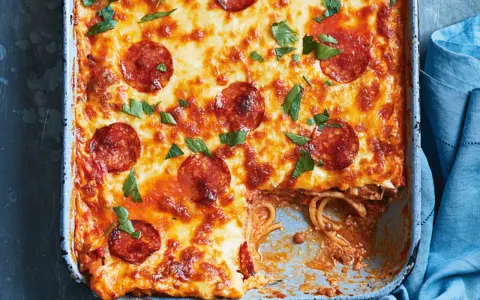 Herzhafter Spaghetti Pizza Auflauf mit geschmolzenem Käse und Pepperoni, garniert mit frischer Petersilie.