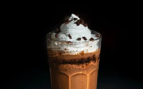 Eiskaffee selbst machen: Ein Glas mit cremigem Eiskaffee, Sahne und Schokostückchen. Perfekt für heiße Tage!