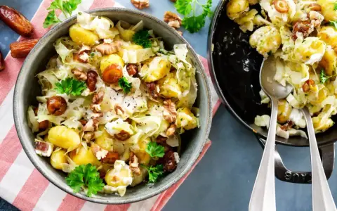 Leckeres rezept mit spitzkohl, Kartoffeln, Datteln und Walnüssen in cremiger Soße, garniert mit Petersilie.
