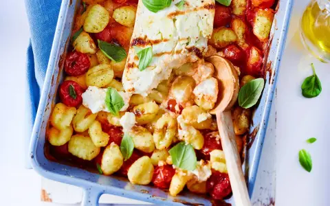 Gnocchi-Pfanne mit Feta, Kirschtomaten und Basilikum in einer blauen Auflaufform, bereit zum Servieren.