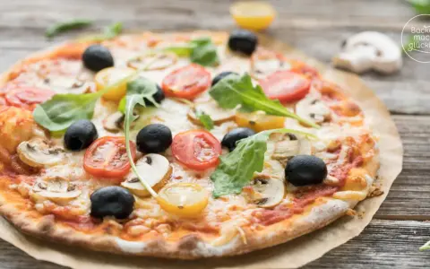 Leckerer Pizzaboden mit Joghurt, belegt mit Tomaten, Oliven und Pilzen.