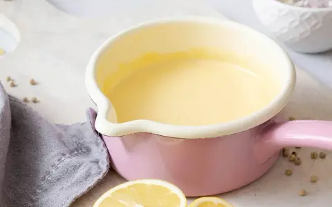 Frisch zubereitete Hollandaise in einem rosa Topf. So einfach ist es, Hollandaise selbst zu machen!