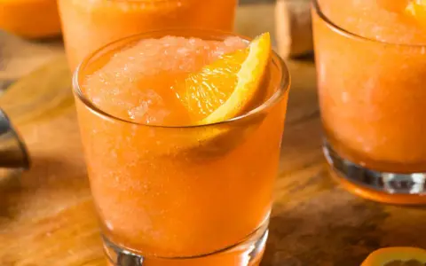Erfrischender Aperol mit Fanta, als Slush serviert und mit einer Orangenspalte garniert. Perfekt für heiße Tage!