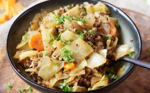 Herzhaftes Gericht aus spitzkohl mit hackfleisch und kartoffeln, garniert mit frischer Petersilie.