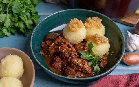 Herzhaftes Rindergulasch nach Omas Rezept, serviert mit Klößen und frischer Petersilie. Ein Klassiker, der immer schmeckt.